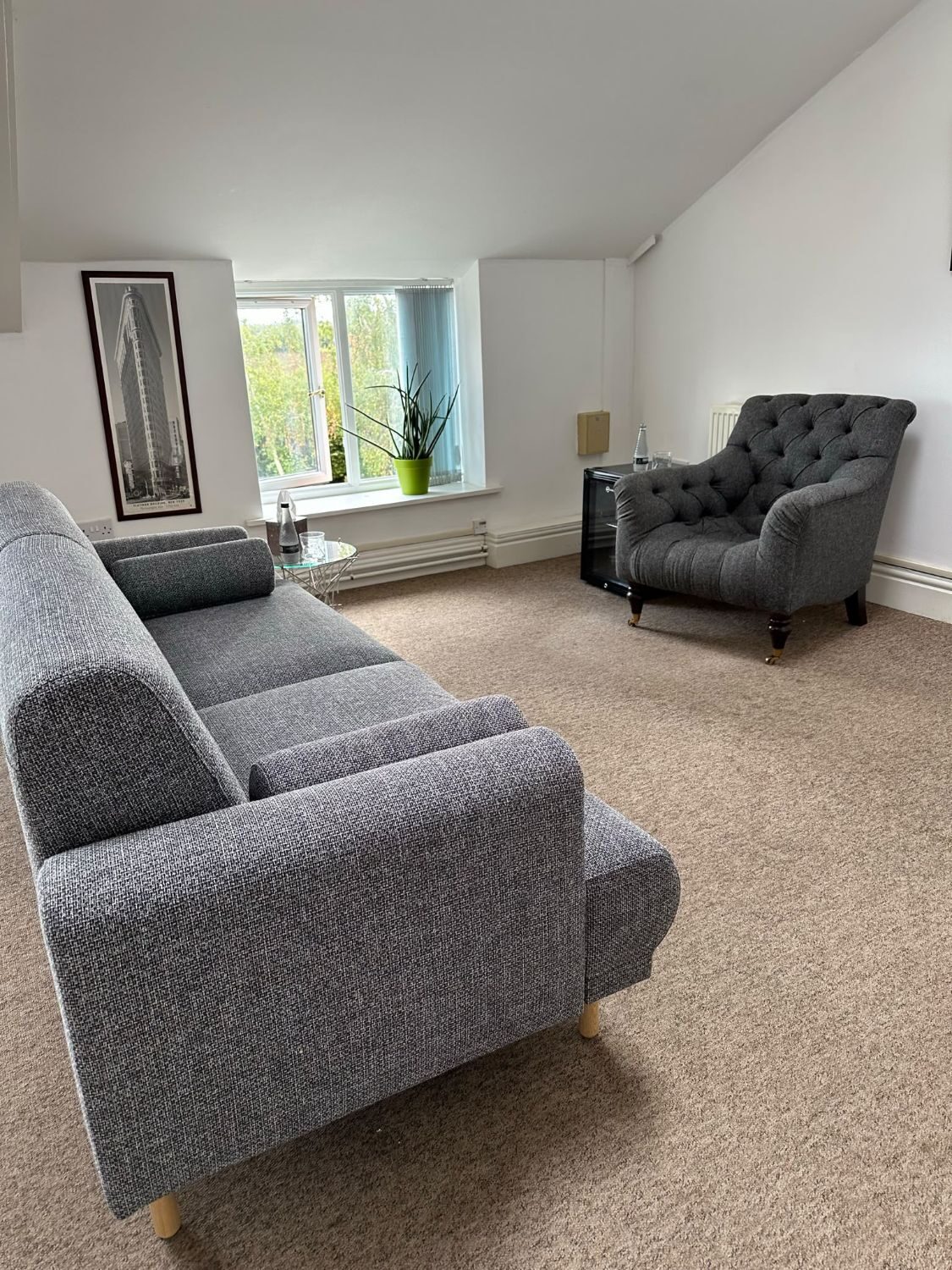 Donna's therapy room: a comfortable seating area with two armchairs and a window looking out onto greenery.